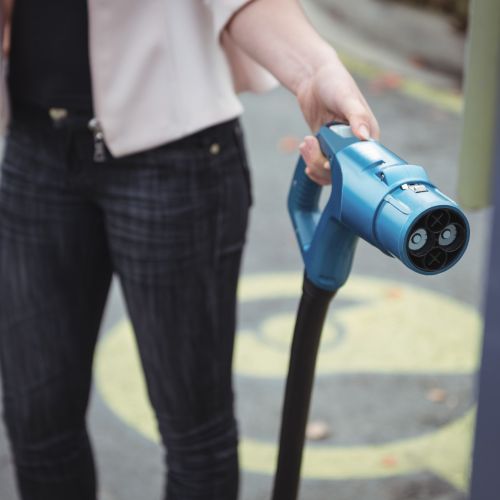 mid-section-woman-charging-electric-car