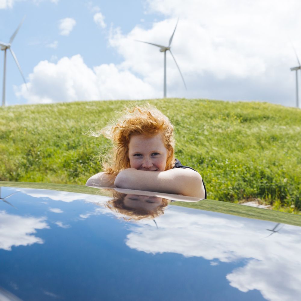 woman-looking-camera-getting-out-car-window-putting-hands-roof